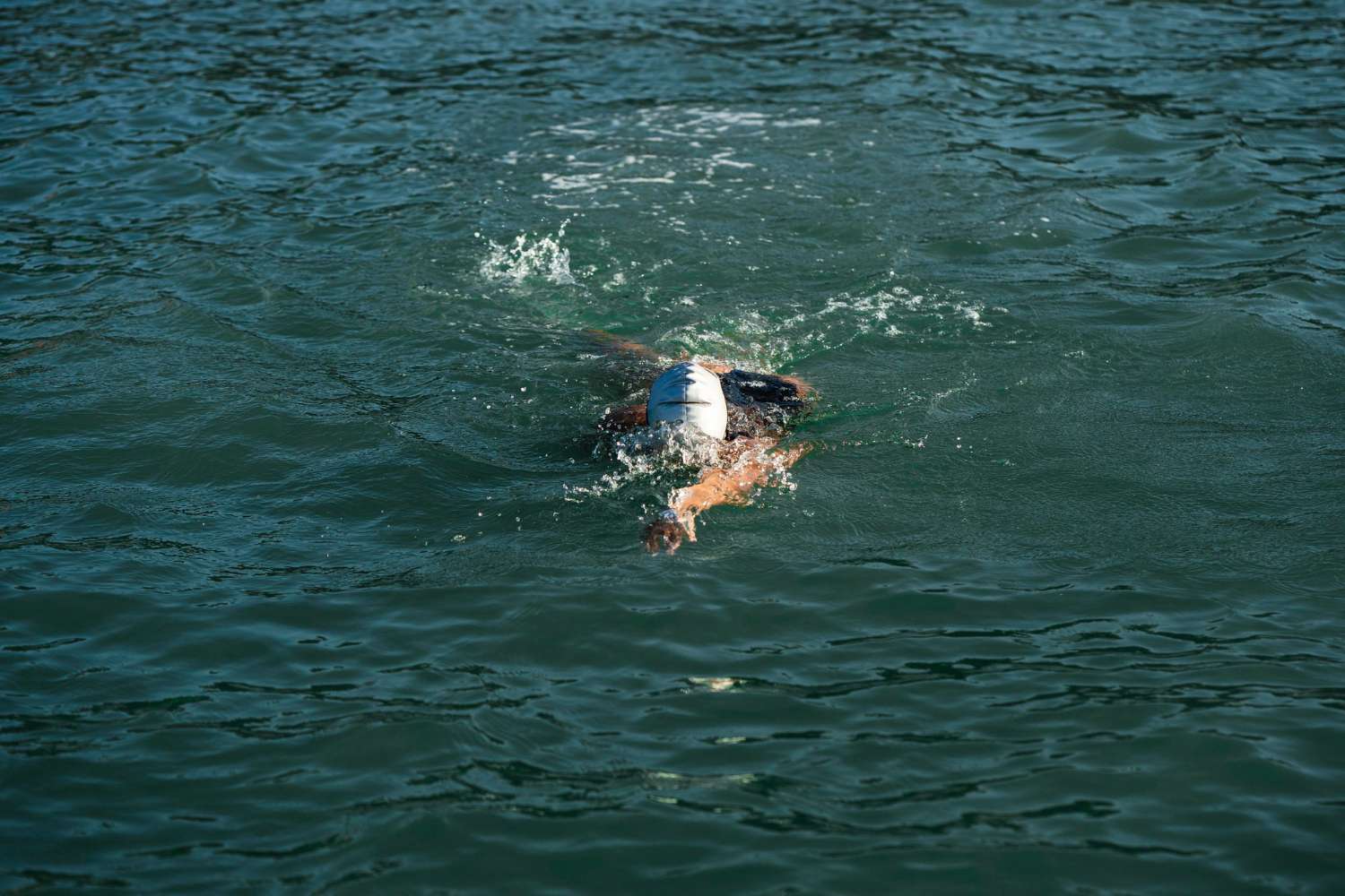 triathlonista pływający w otwartej wodzie przed zawodami