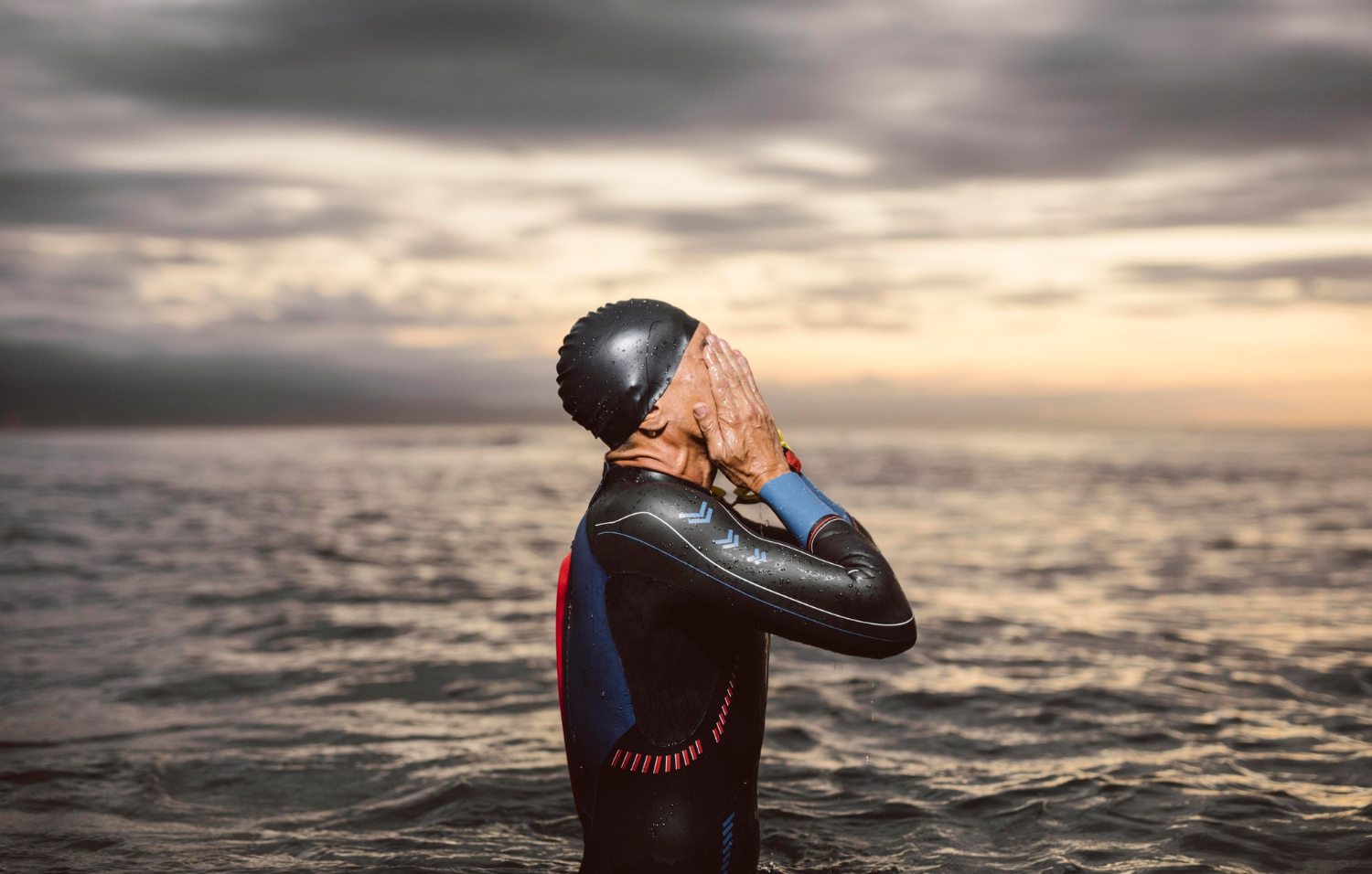 triathlonista zmęczony po treningu pływackim w piance neoprenowej